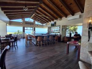 a restaurant with a bar and tables and chairs at Lakeside Apartment in Oubaai Golf Estate in George