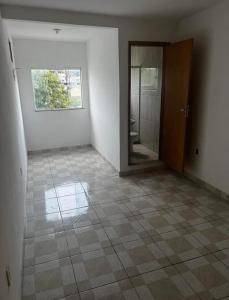 an empty room with a door and a tiled floor at Confort Casa in São João de Meriti