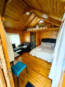 a bedroom in a log cabin with a bed and a couch at Cabañas El Condominio Guatavita in Guatavita