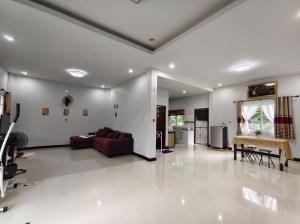 a living room with a couch and a table at BaanRatsitornHomestay in Langu