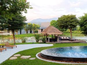 a backyard with a swimming pool and a gazebo at Chombua MaeWang ชมบัว in Chiang Mai