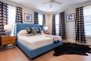 a blue bed in a bedroom with windows at Watch Hill Manor Bourbon Commons in Louisville +47 photos