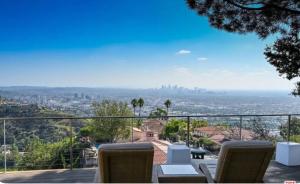 a balcony with chairs and a view of the city at Secluded Luxury Hollywood Hills Retreat in Los Angeles