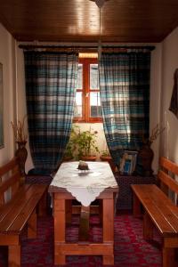 a room with a table and benches and a window at To Petrino Guesthouse in Agios Germanos
