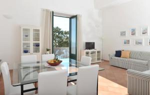 ミノーリにあるLa Tuga - Ravello Accommodationのダイニングルーム(ガラステーブル、白い椅子付)