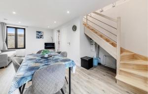 a dining room with a table and a staircase at Pet Friendly Apartment in Saint-Benoît-des-Ondes