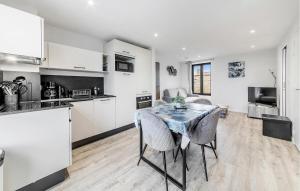 a kitchen and living room with a table and chairs at Pet Friendly Apartment in Saint-Benoît-des-Ondes