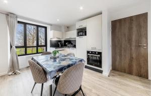 a kitchen and dining room with a table and chairs at Pet Friendly Apartment in Saint-Benoît-des-Ondes