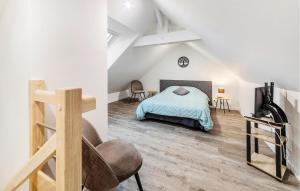 a attic bedroom with a bed and a chair at Pet Friendly Apartment in Saint-Benoît-des-Ondes