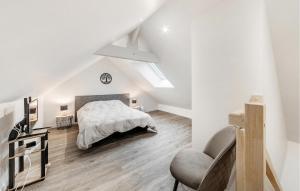 a white bedroom with a bed and a chair at Beach Front Apartment in Saint-Benoît-des-Ondes