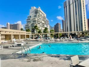 a swimming pool in a city with tall buildings at ~Four-star serviced apartment in Honolulu