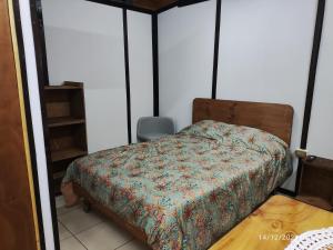 a bedroom with a bed and a chair in it at RdA Apartment in Pichilemu +2 photos