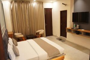 a hotel room with a bed and a flat screen tv at The Grand View in Baijnāth