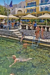 a group of people in the water at a swimming pool at Nireus Hotel in Symi