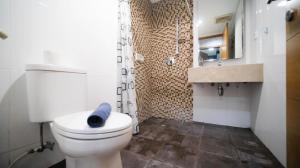 e bagno con servizi igienici bianchi e doccia. di Homey and Cozy Living 2BR Apartment at Aryaduta Residence Surabaya By Travelio a Surabaya Altre 11 foto