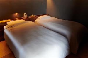 Una cama o camas en una habitación de GOTO island ROKGOUTEI五島列島福江島のモダンな一棟貸ヴィラ