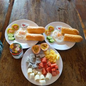 two plates of breakfast food on a wooden table at FamilyHouse & Trekking in Banlung +37 photos