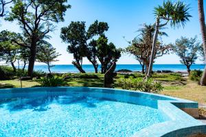 a swimming pool with the beach in the background at Yoho Beach Resort Kenting in Hengchun South Gate