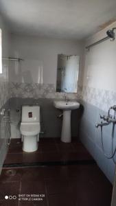 a bathroom with a toilet and a sink at Highway Homestay in Kumta