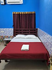 ポンディシェリにあるSree Villa Homestayの赤毛布と青い壁のベッド