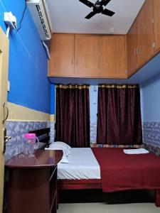 ポンディシェリにあるSree Villa Homestayのベッドと天井扇風機のある寝室