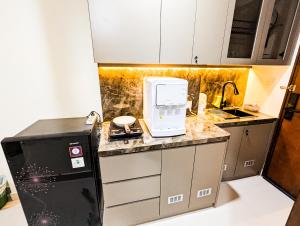 a small kitchen with a sink and a microwave at Lovina 806 at Pollux Meisterstadt in Batam Center