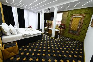 a hotel room with a bed and a mirror at Emir Palace in Popeşti-Leordeni