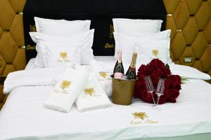 a white bed with flowers and wine bottles on it at Emir Palace in Popeşti-Leordeni +31 photos