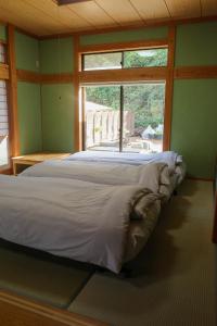 a large bed in a room with a window at くつろ郷Kutsuro-go in Kawatana +100 photos