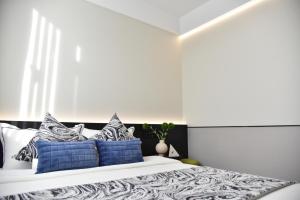 a bedroom with a bed with blue and white pillows at Beijing Tiananmen Wangfujing Ruibeting Apartment Hotel in Beijing