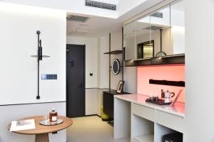 a kitchen with pink and white walls and a table at Beijing Tiananmen Wangfujing Ruibeting Apartment Hotel in Beijing