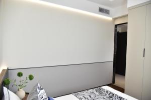 a bedroom with a bed with a white headboard at Beijing Tiananmen Wangfujing Ruibeting Apartment Hotel in Beijing