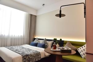 a hotel room with a bed and a table at Beijing Tiananmen Wangfujing Ruibeting Apartment Hotel in Beijing