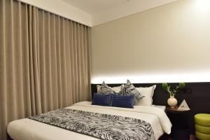 a bedroom with a large bed with blue pillows at Beijing Tiananmen Wangfujing Ruibeting Apartment Hotel in Beijing