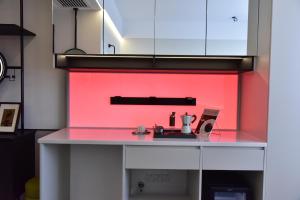a kitchen with a counter with a red wall at Beijing Tiananmen Wangfujing Ruibeting Apartment Hotel in Beijing