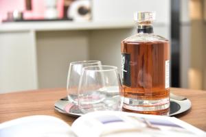 a bottle of alcohol sitting on a table with two glasses at Beijing Tiananmen Wangfujing Ruibeting Apartment Hotel in Beijing