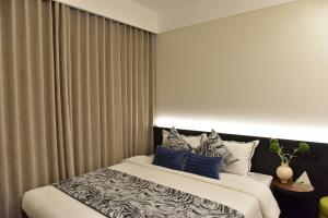 a bedroom with a large bed with blue pillows at Beijing Tiananmen Wangfujing Ruibeting Apartment Hotel in Beijing