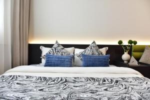 a bedroom with a large bed with blue pillows at Beijing Tiananmen Wangfujing Ruibeting Apartment Hotel in Beijing