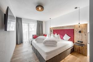 a hotel room with two beds and a red headboard at Apart Natur in Sölden