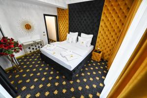 a hotel room with a large bed with white sheets at Emir Palace in Popeşti-Leordeni