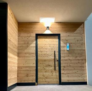 a room with a wooden wall with a door at Cá de Lares in Peio