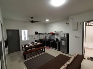 a living room with a couch and a kitchen at The Aliff Residences in Johor Bahru