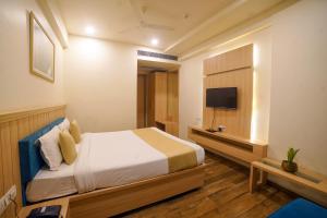una camera da letto con un letto e una TV a schermo piatto di Hotel Centre Park Bhopal a Bhopal
