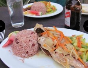 a plate of food with meat and vegetables on a table at Hayley's Paradise Limited in Little Bay