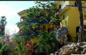 a yellow building with plants on the side of it at Hayley's Paradise Limited in Little Bay