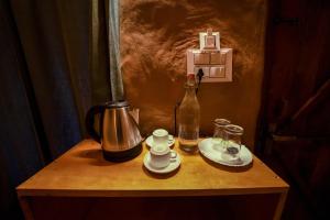 - une table avec une cafetière et une bouteille dans l'établissement Snow Smile Camps Munnar, à Munnar 75 autres photos