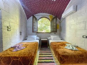 阿斯旺Kashta Nubian Guest Houst的有窗户的房间里有两张床