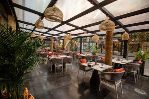 安曼The Abdali Boulevard Hotel的建筑物内有桌椅的餐厅