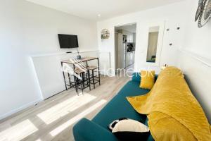 salon z niebieską kanapą i stołem w obiekcie Maisonnette de charme Refaite à neuf Vue mer w mieście Guidel