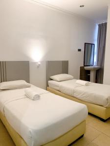 Postel nebo postele na pokoji v ubytování One Stop Hotel Ipoh